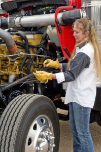 A driver doing her pre-trip inspection prior to leaving